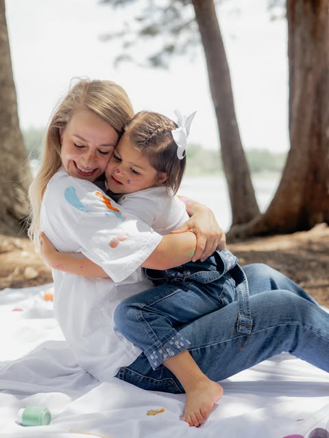 Mother embracing her daughters outdoors